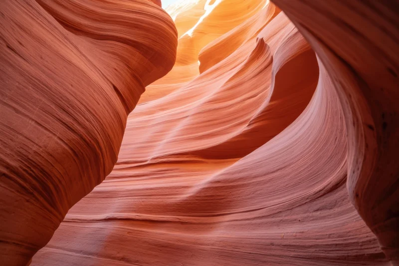 Sunlit sandstone slot canyon with flowing orange and pink rock formations