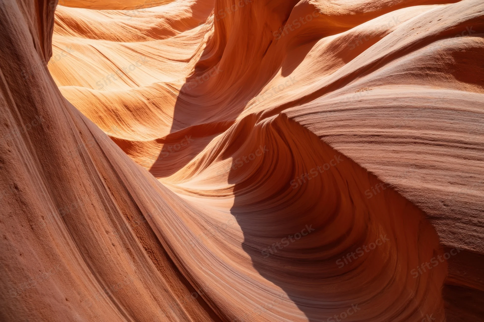 Sunlit sandstone slot canyon with flowing orange and pink rock formations