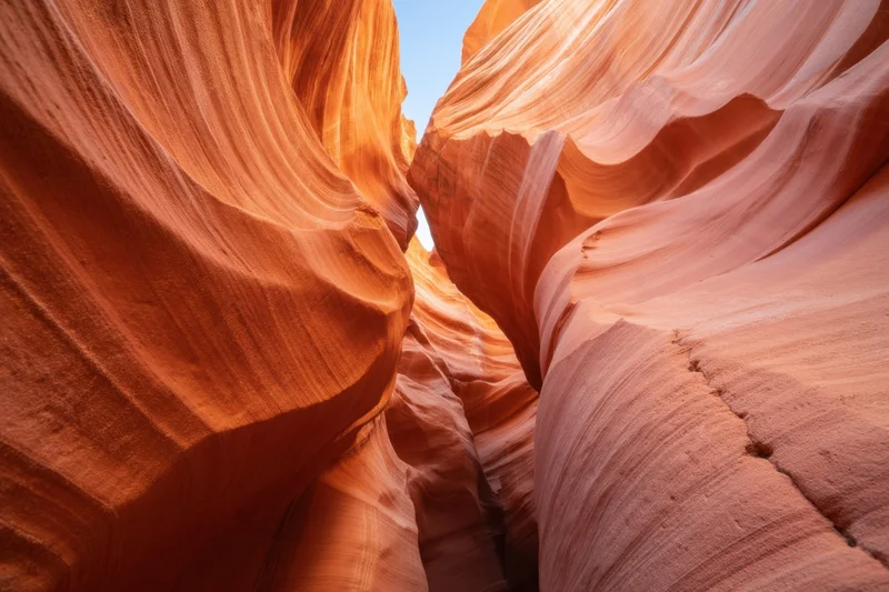 Sunlit sandstone slot canyon with flowing orange and pink rock formations