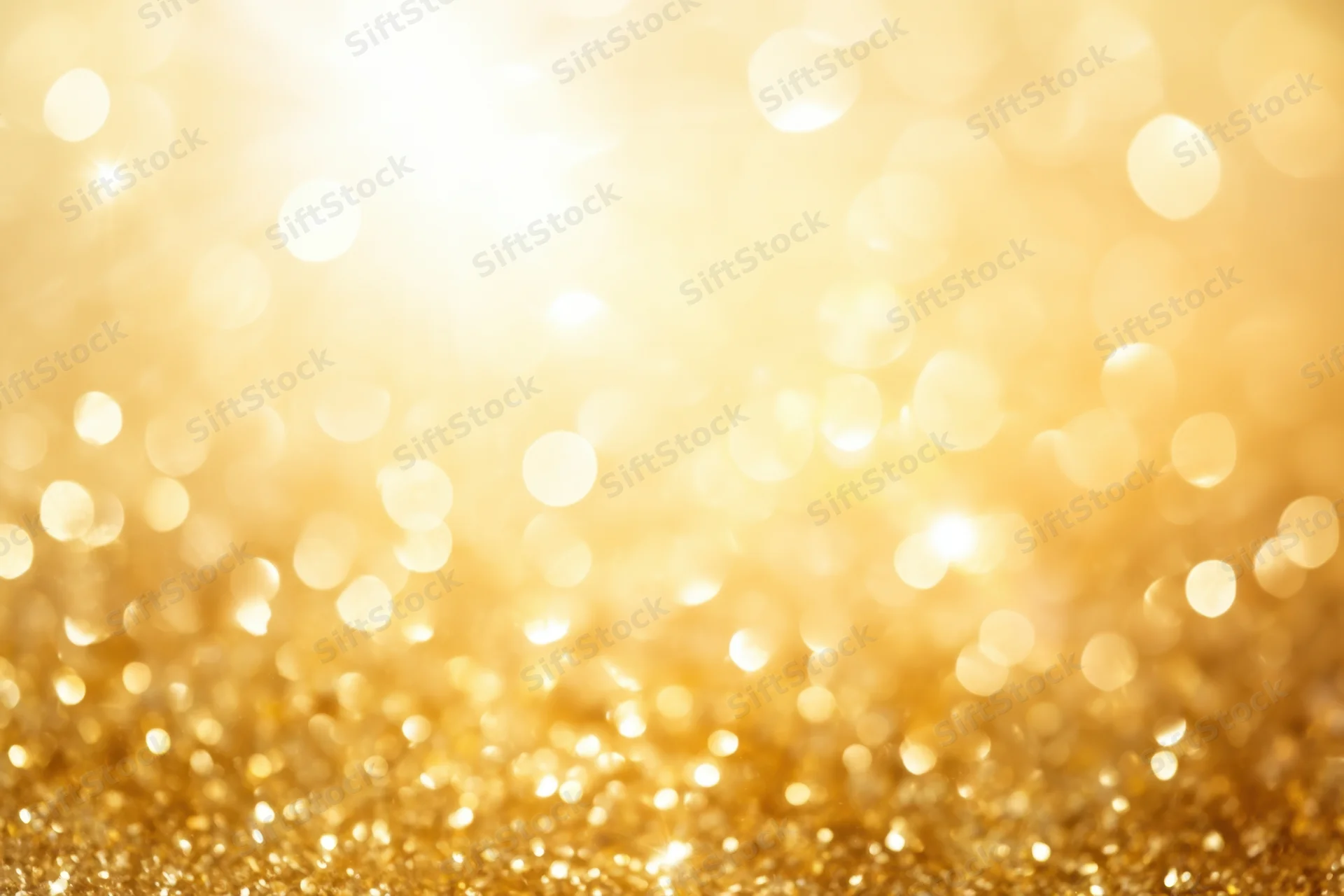 Golden glitter with soft bokeh lights creating a festive abstract background