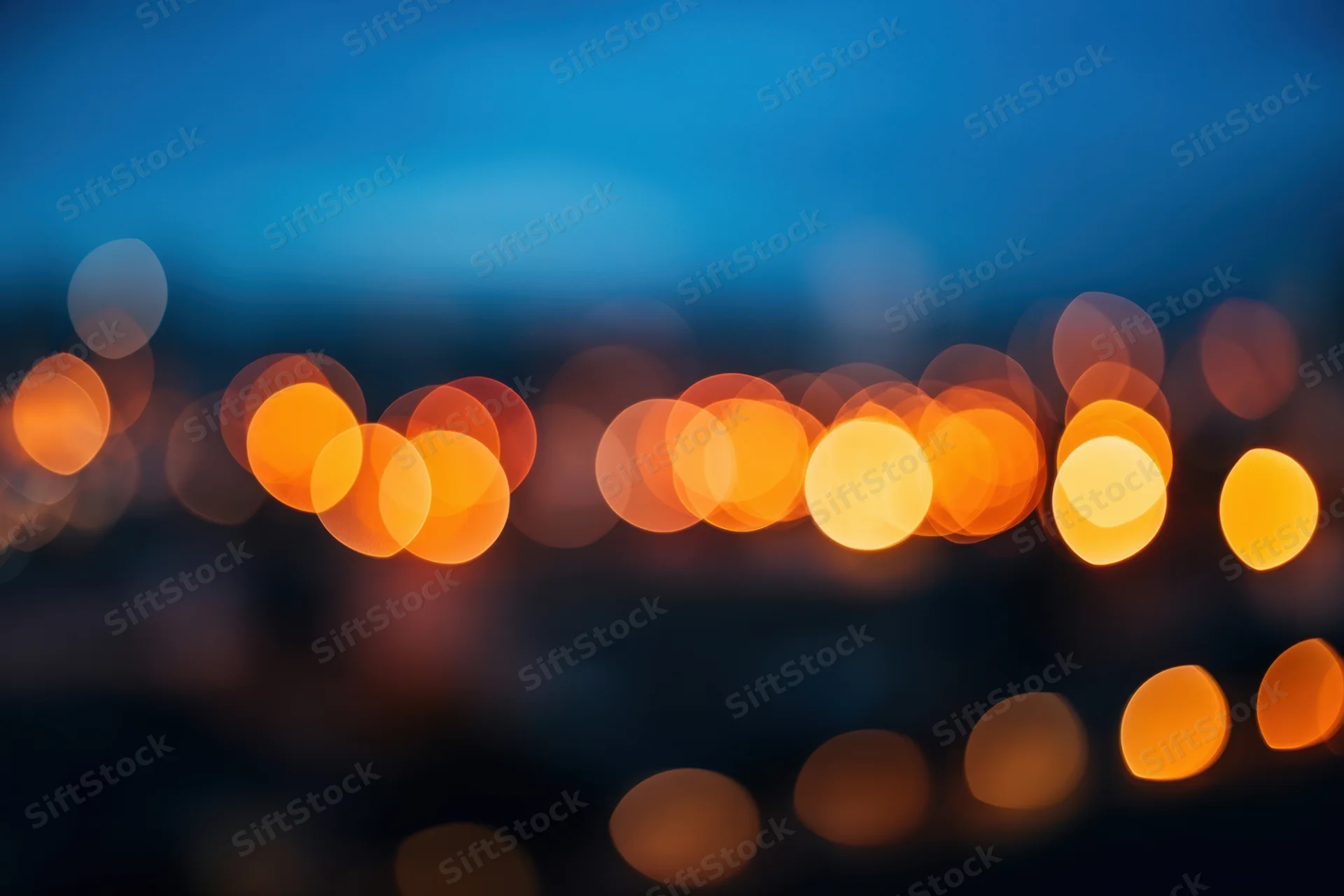 Blurred city lights forming warm orange and yellow bokeh at night