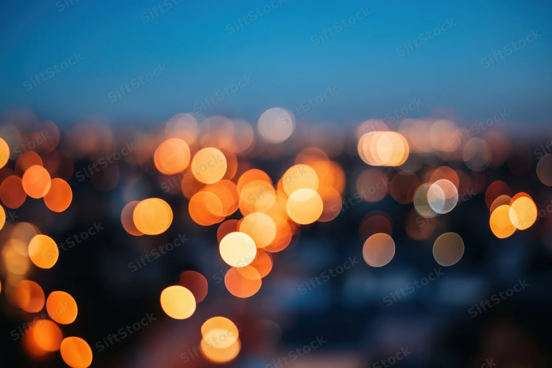Blurred city lights forming warm orange and yellow bokeh at night
