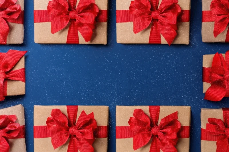 Wrapped gifts with red bows arranged in a frame on a blue background