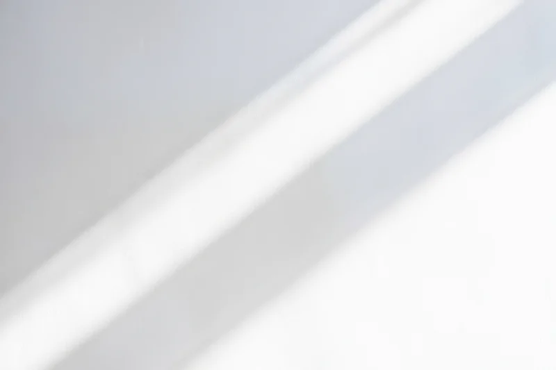 Diagonal light streaks on a bright white minimal background