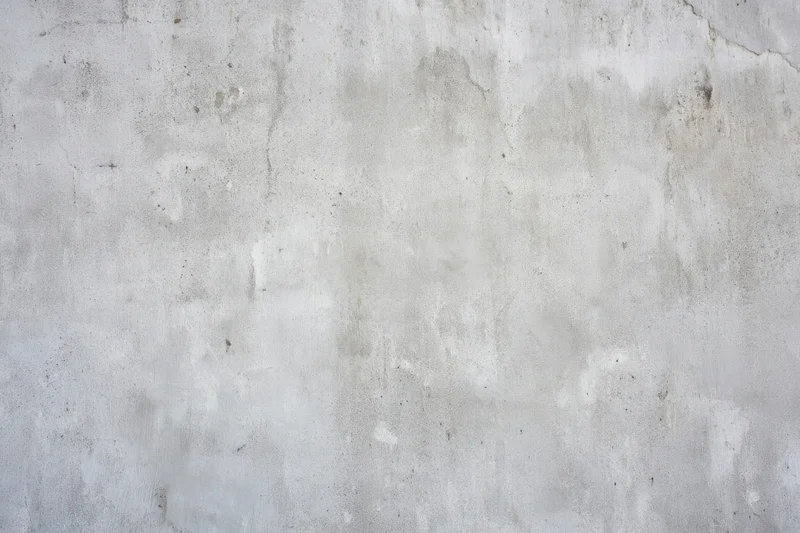Close-up of a weathered light gray concrete wall surface