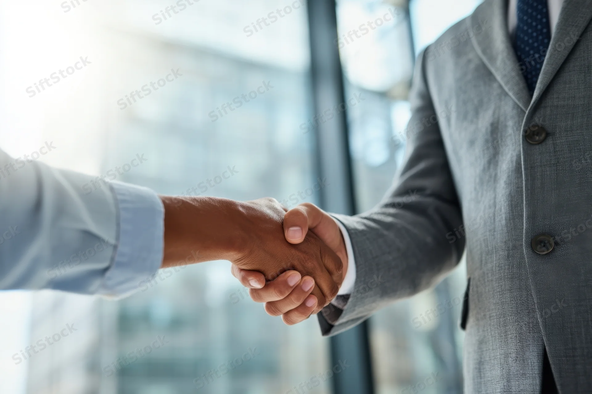 Two professionals shaking hands in a modern office setting