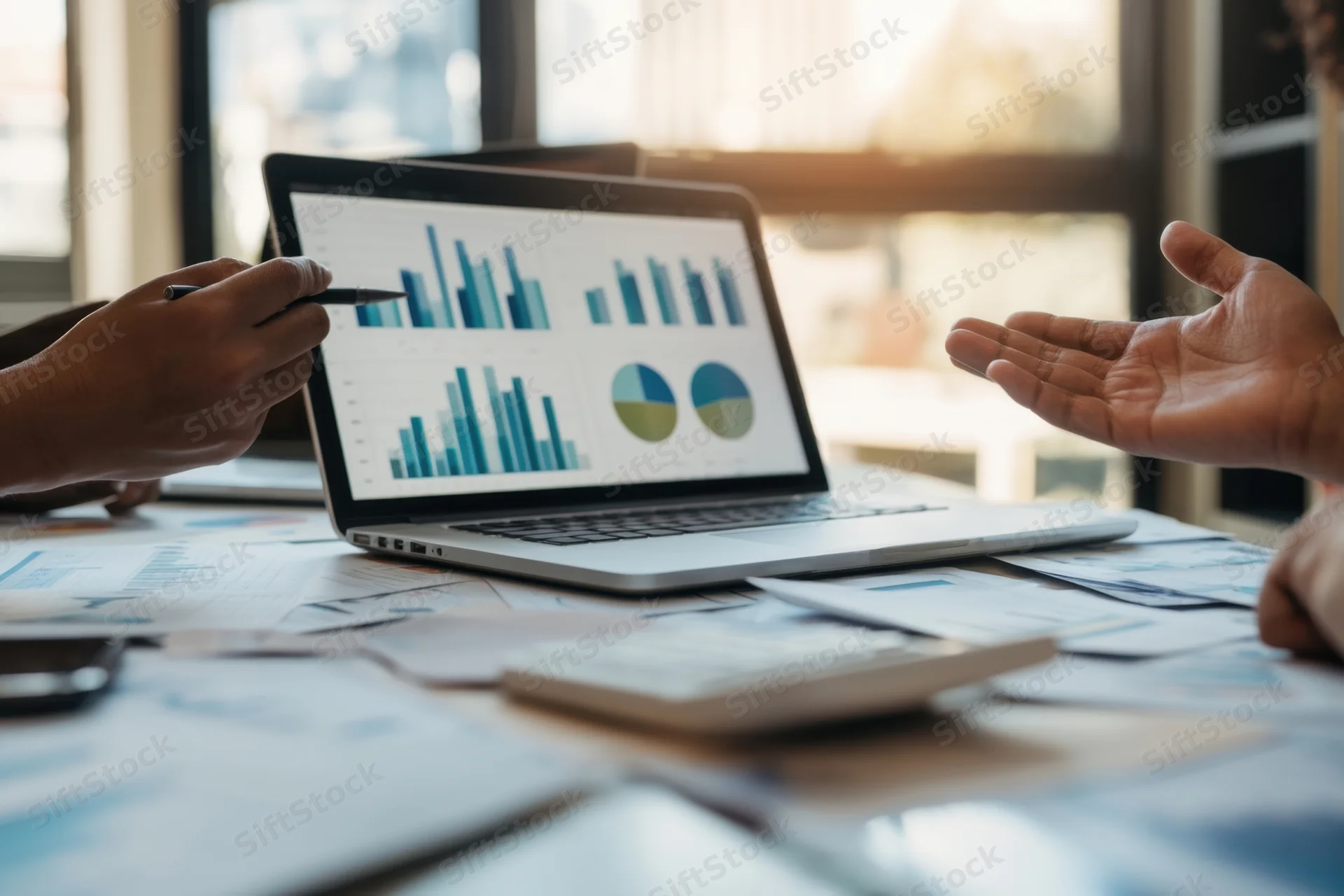 Two professionals discussing business analytics displayed on a laptop screen in an office meeting setting