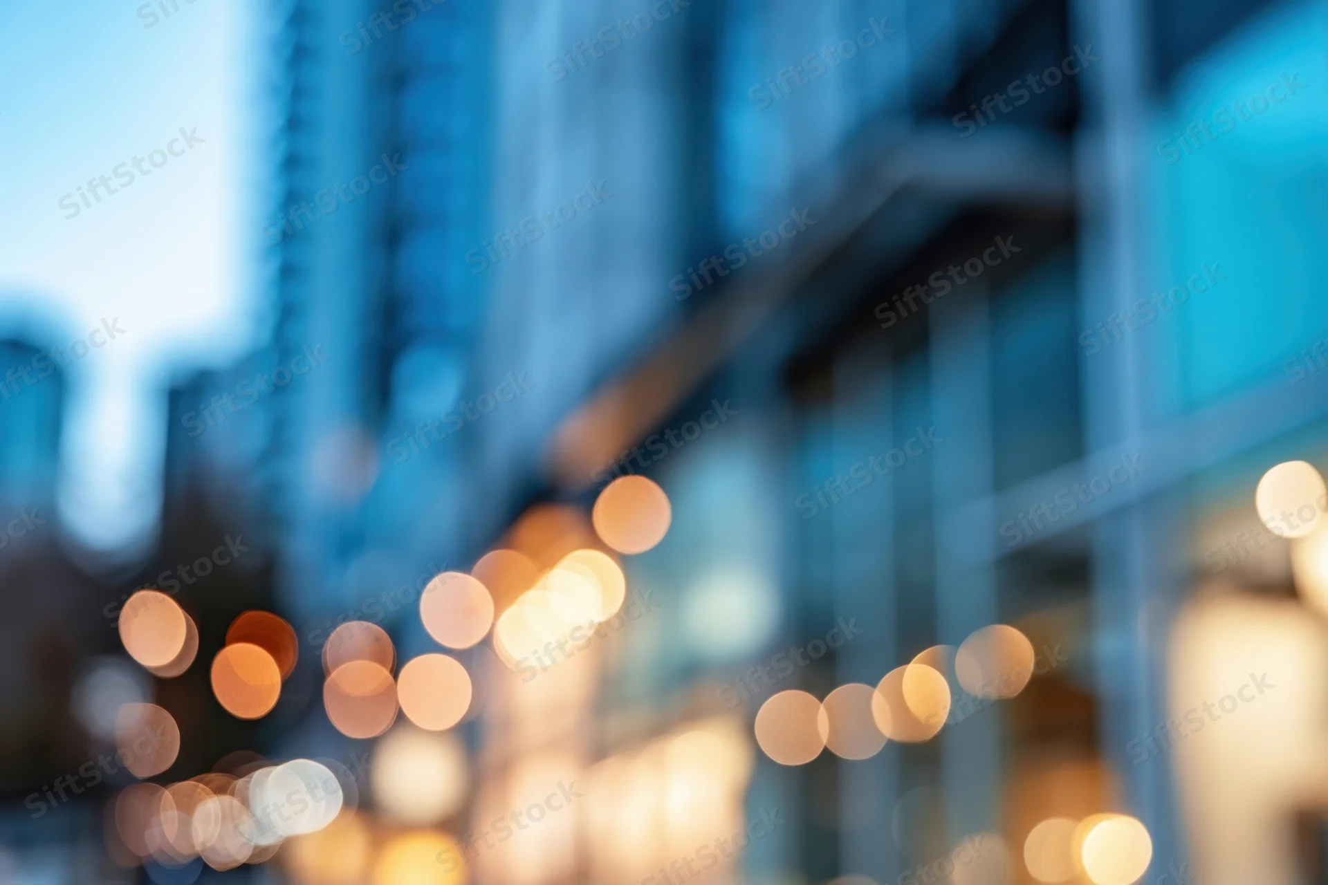 Blurred cityscape with bokeh lights from glass storefronts at evening
