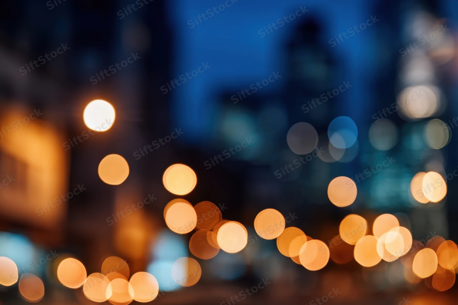 Blurred city lights at night with warm bokeh against cool blue background