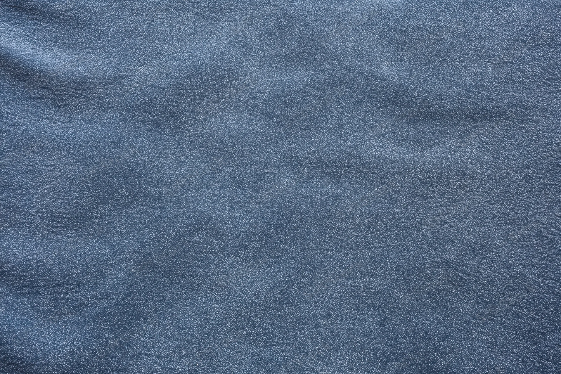 Close-up of blue-gray denim fabric texture with visible weave and slight folds
