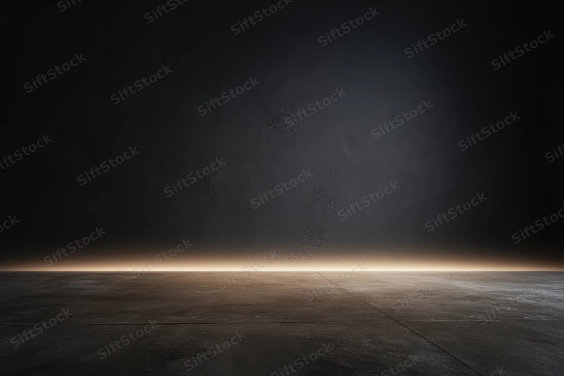 Empty studio interior with textured charcoal wall and concrete floor under dim spotlight lighting