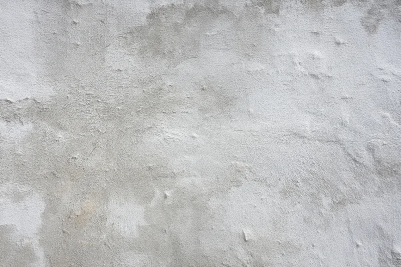 Weathered gray concrete wall with rough texture and patches of wear