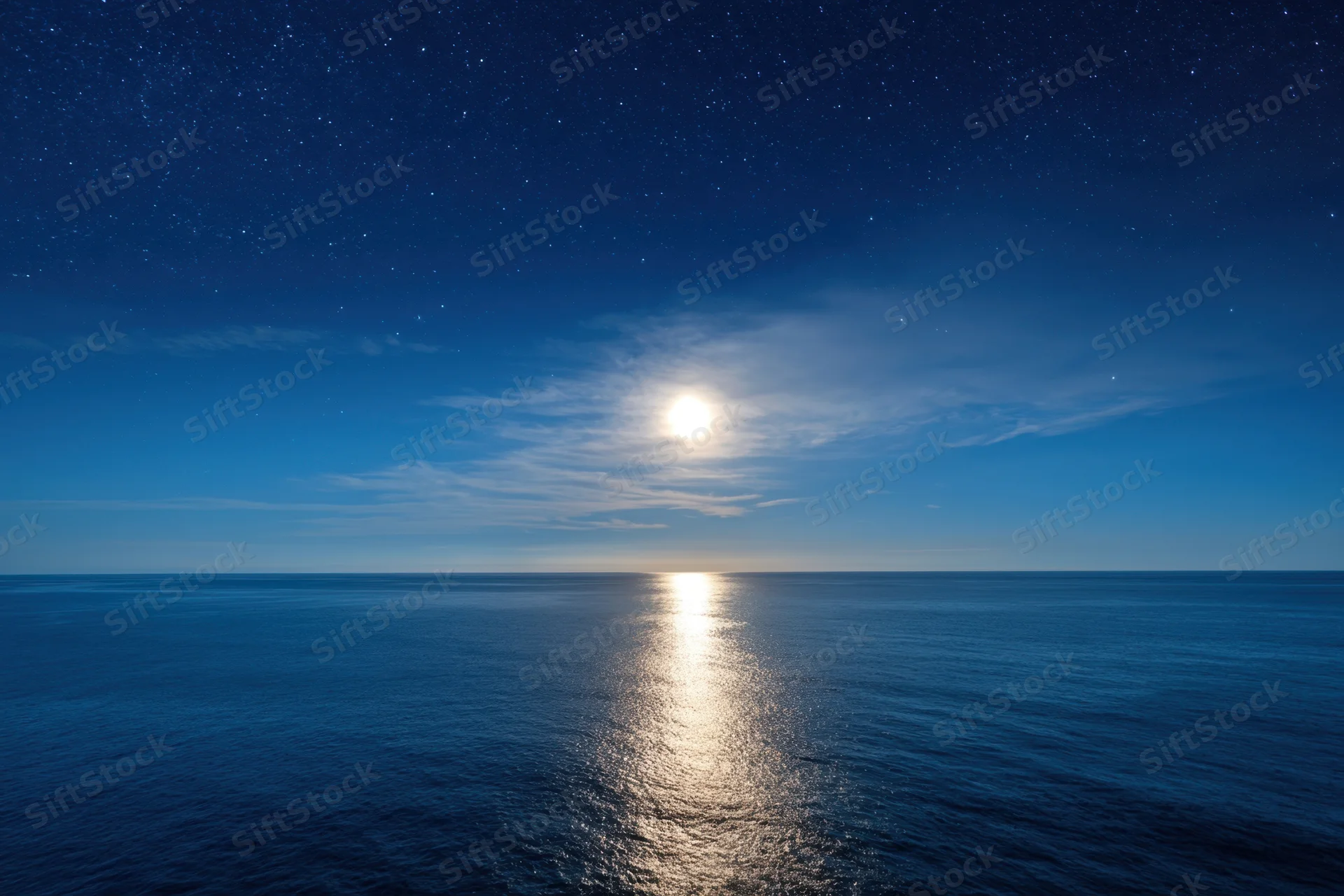 Full moon glowing over calm ocean at night with stars in sky and reflection on water
