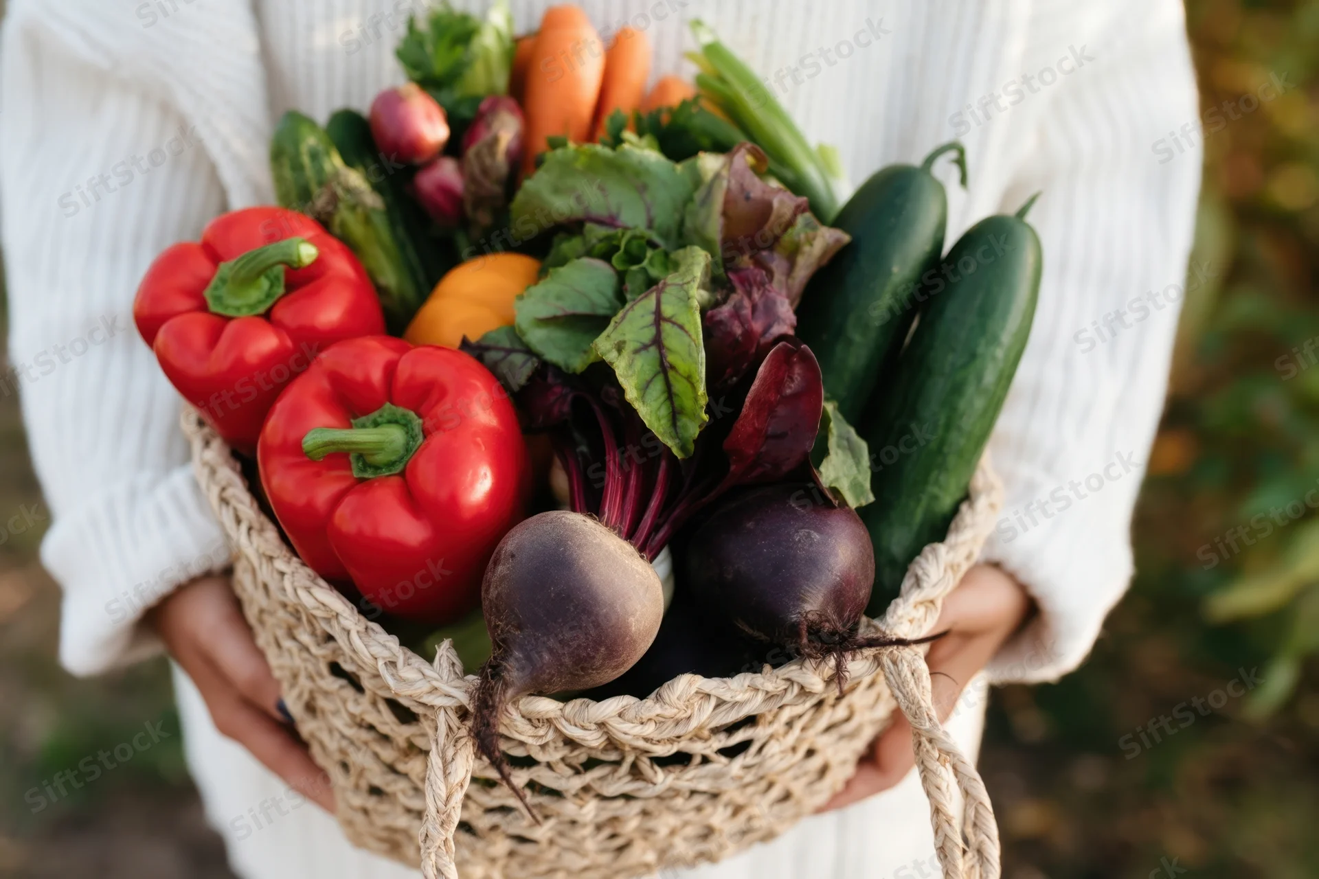 Woman holding a woven basket overflowing with fresh vegetables in a garden