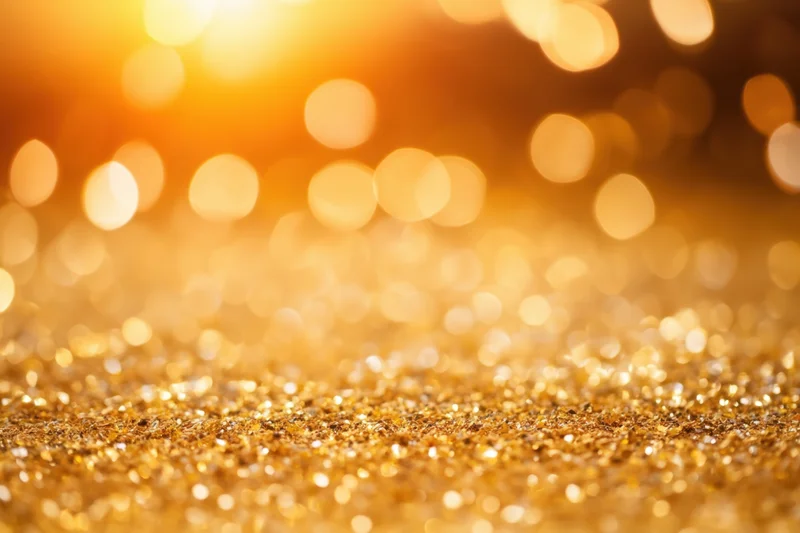Shimmering golden glitter surface with soft bokeh lights in the background
