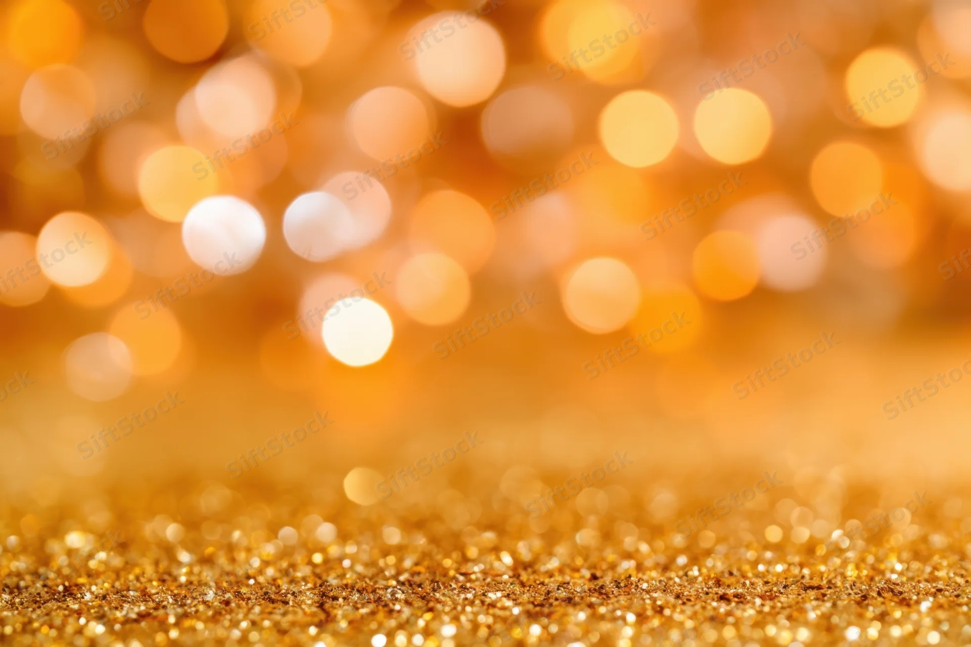 Shimmering golden glitter surface with soft bokeh lights in background