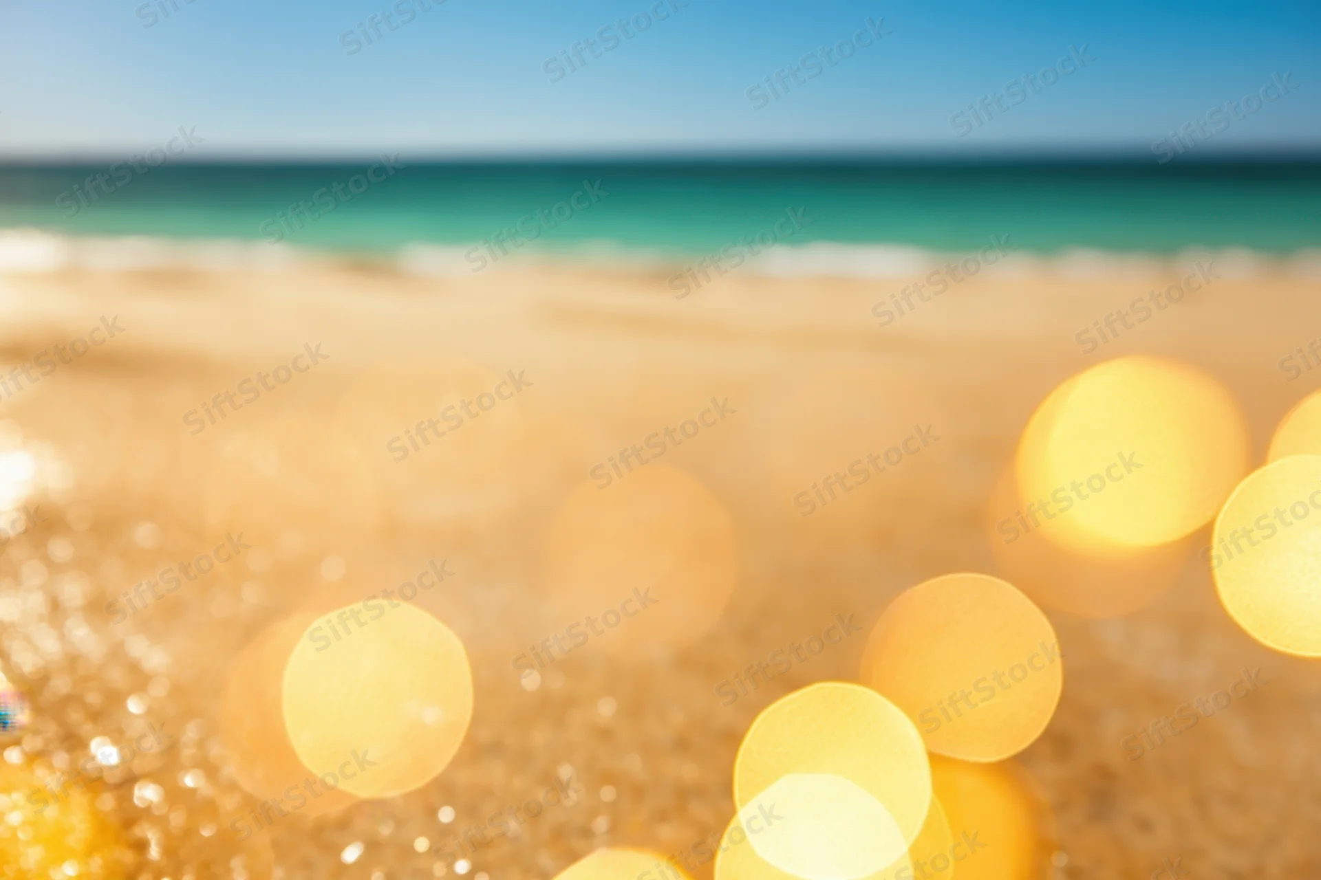 Sunlit beach with golden sand and clear blue sky in the background