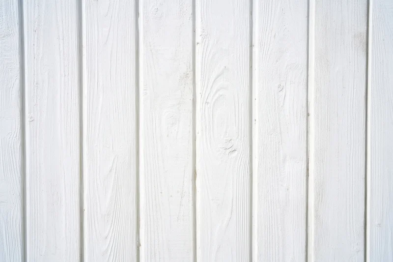 Whitewashed wooden plank wall with vertical boards and visible grain texture