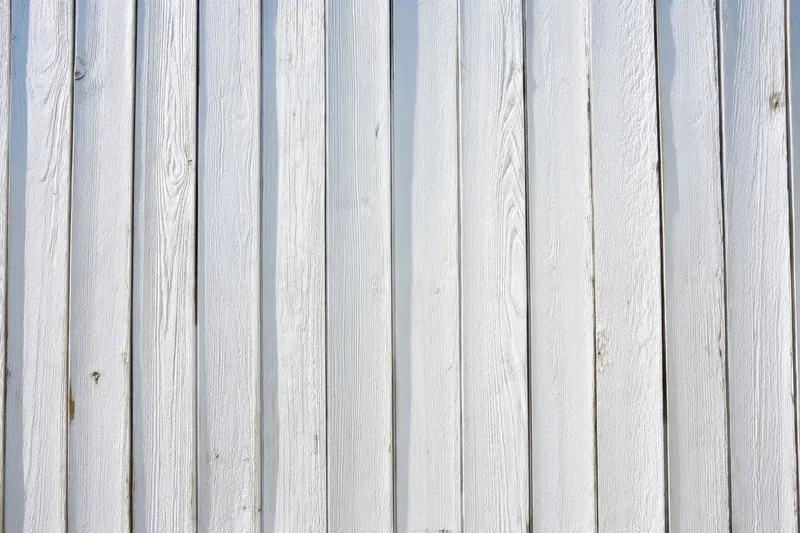 Whitewashed wooden planks arranged vertically as an exterior wall surface