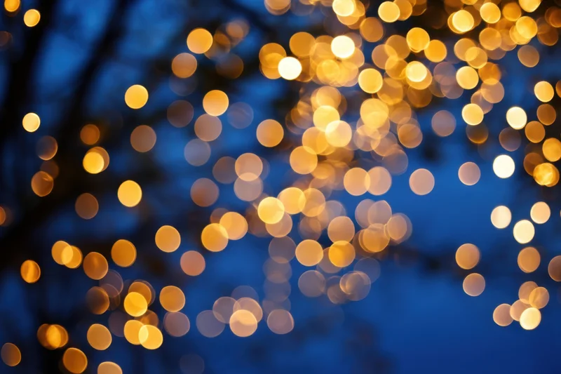 Warm golden bokeh lights scattered over deep blue night sky