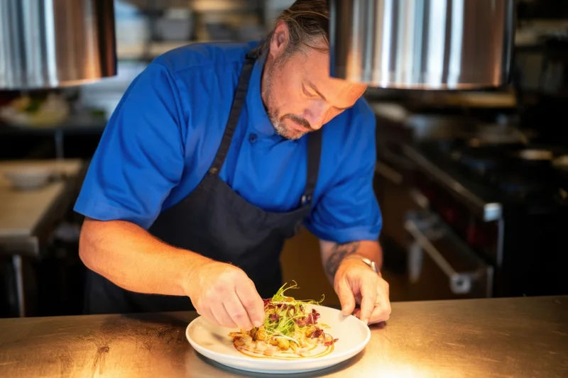 Chef plating a gourmet dish in a restaurant kitchen