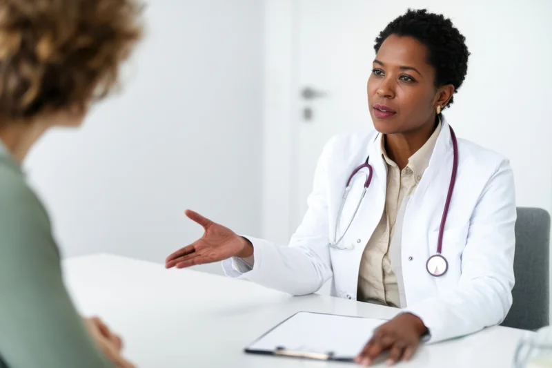 Doctor in white coat explaining to patient during consultation in clinic office