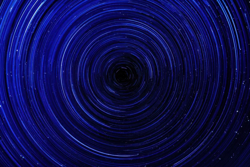 Circular blue light trails from stars rotating in the night sky