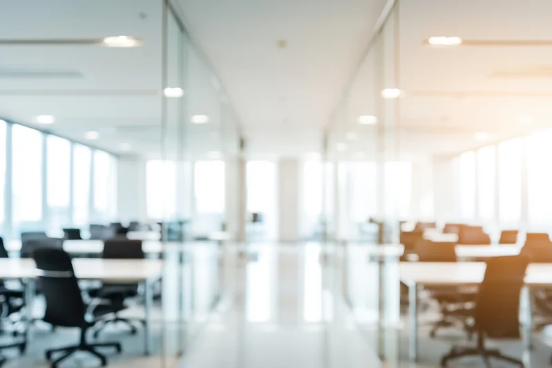Modern office conference room with glass walls and tables arranged for meetings