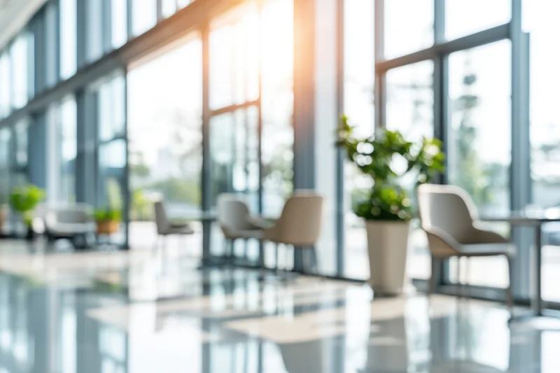 Modern office lobby with floor-to-ceiling glass walls and minimalist furniture
