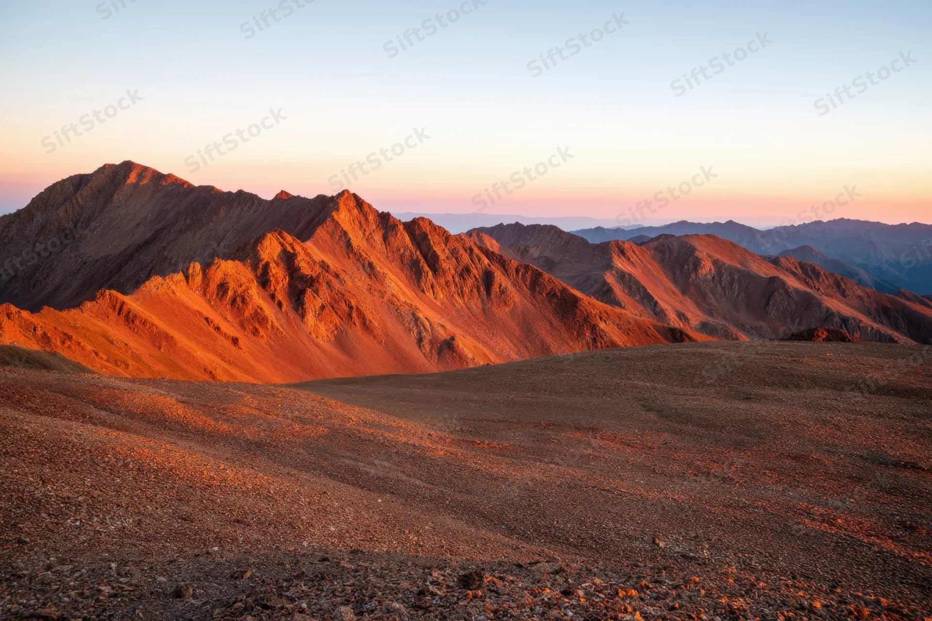 Mountain range bathed in golden hour light at sunset