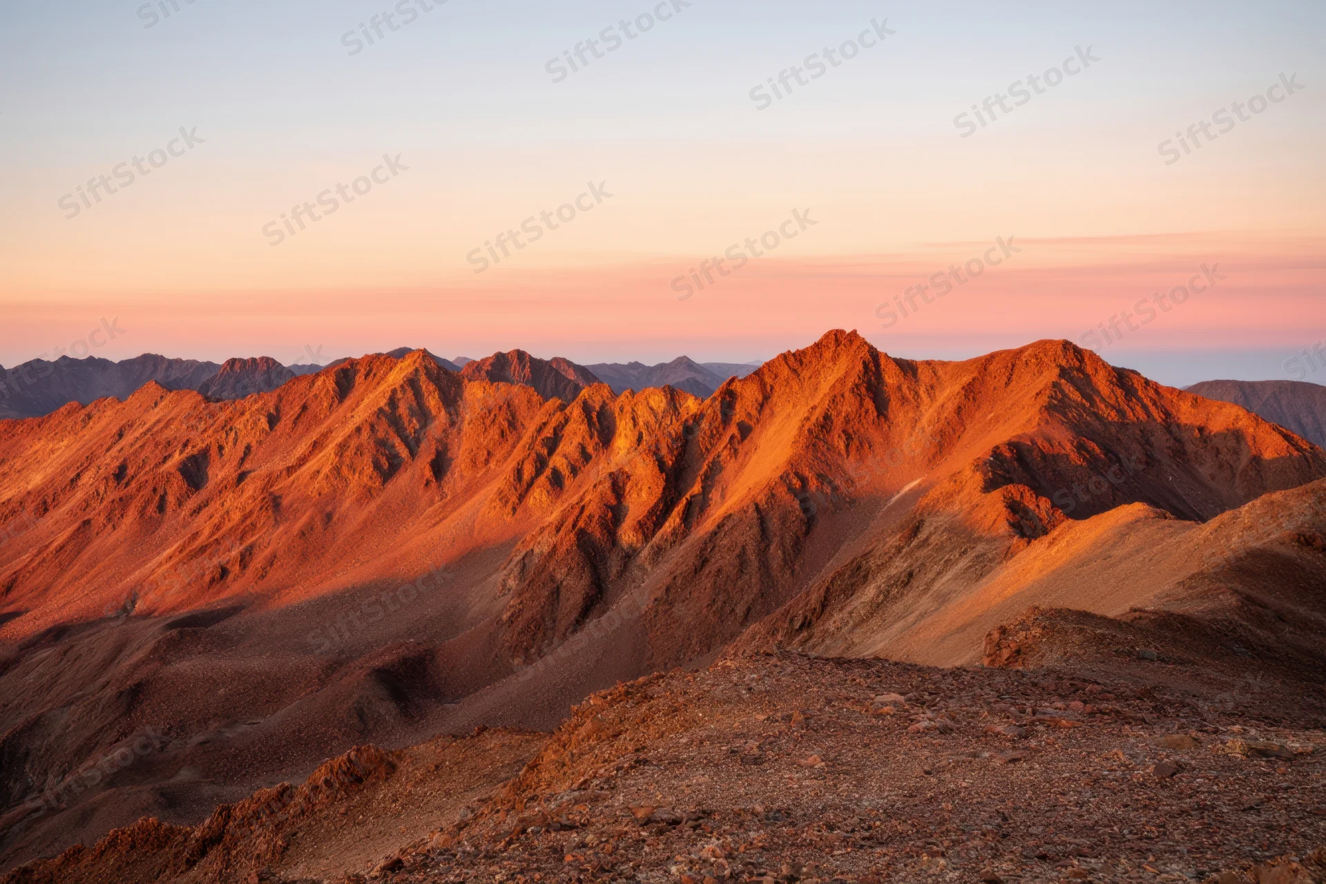 Rugged mountain range under golden hour light at sunset