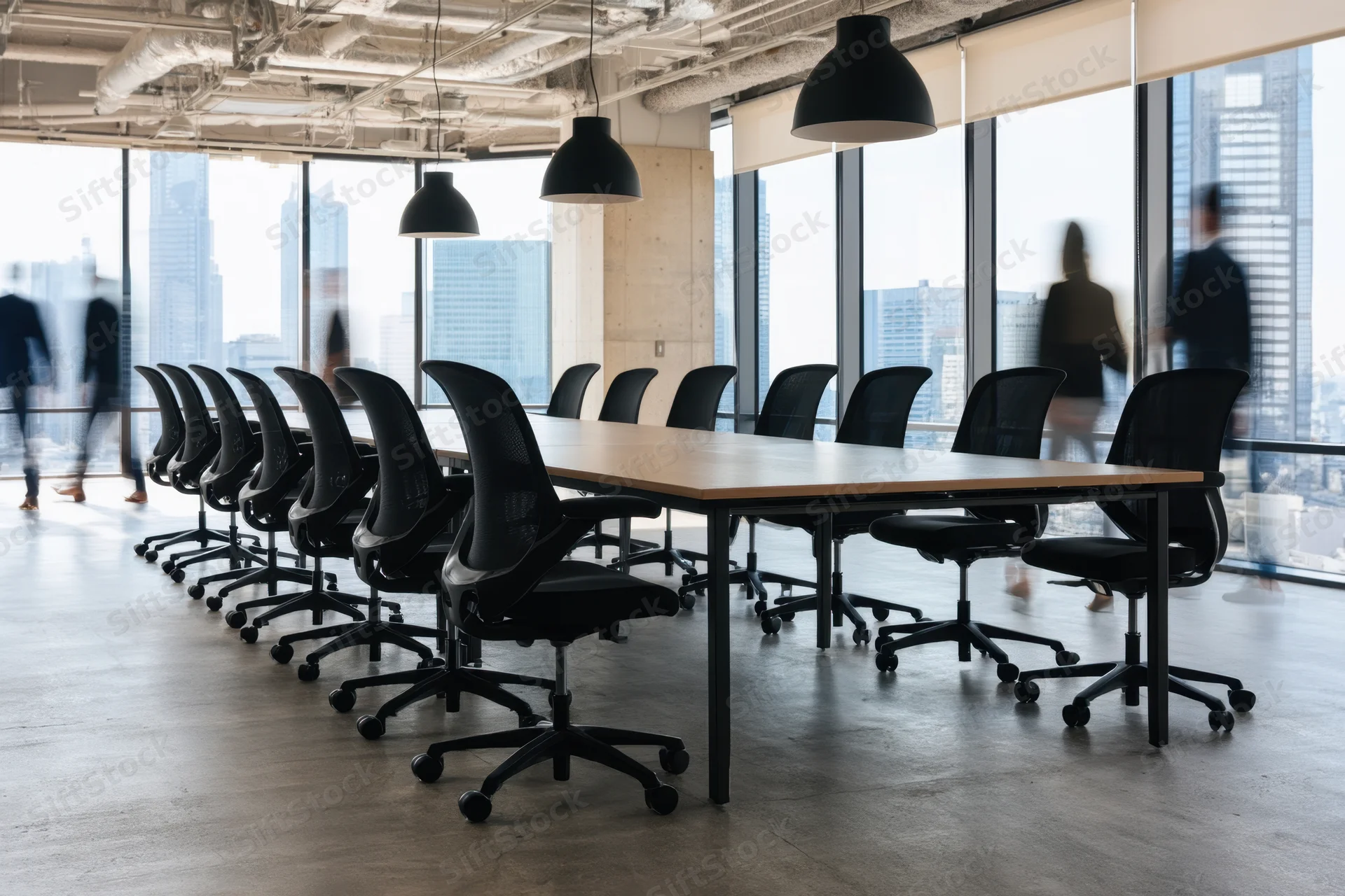 Long conference table with black chairs in a modern open-plan office with city view