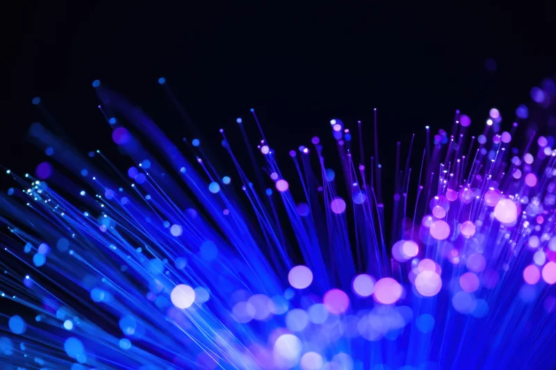 Glowing blue and purple fiber-optic strands against dark background