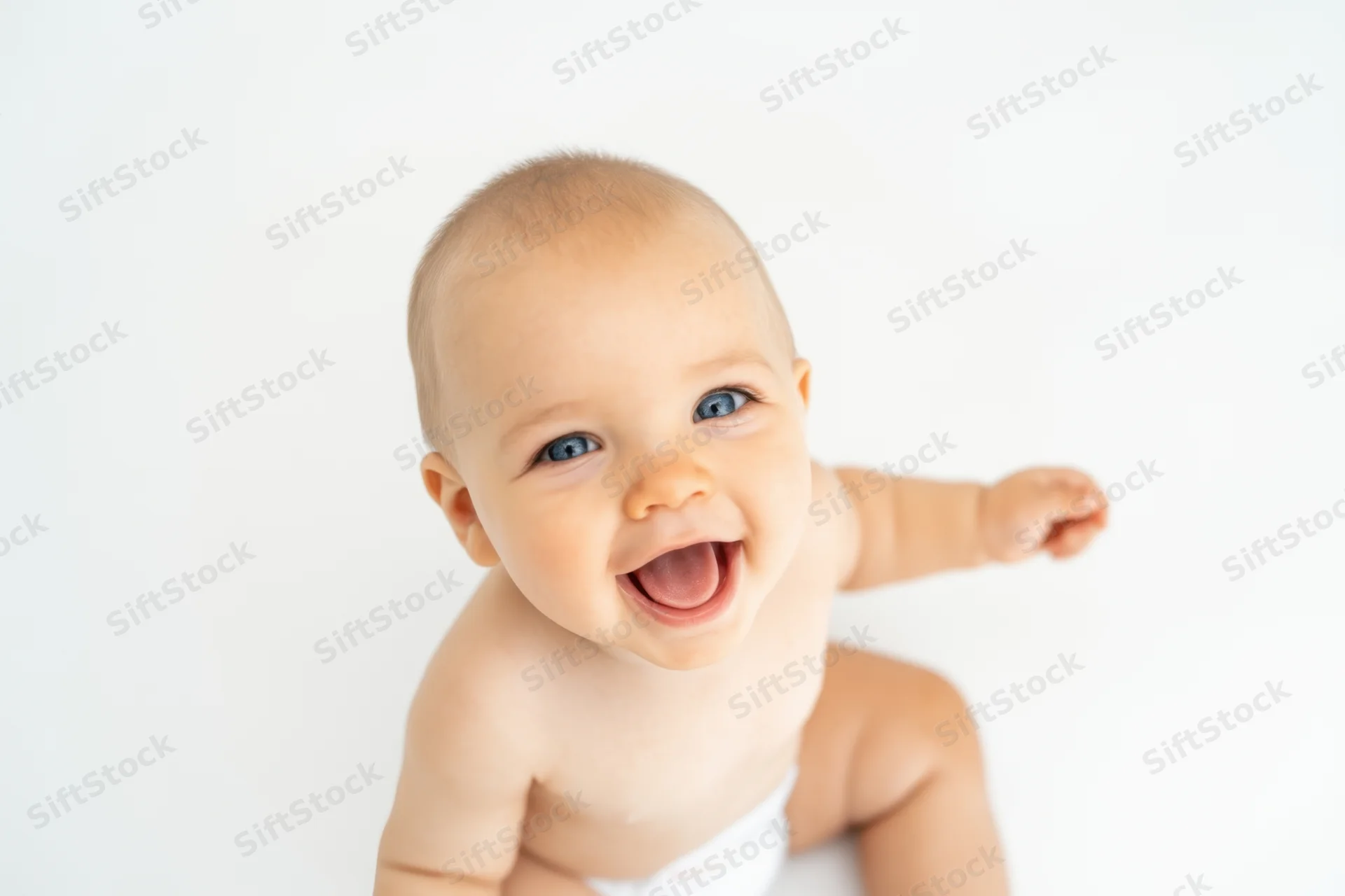Baby smiling with blue eyes on white studio background