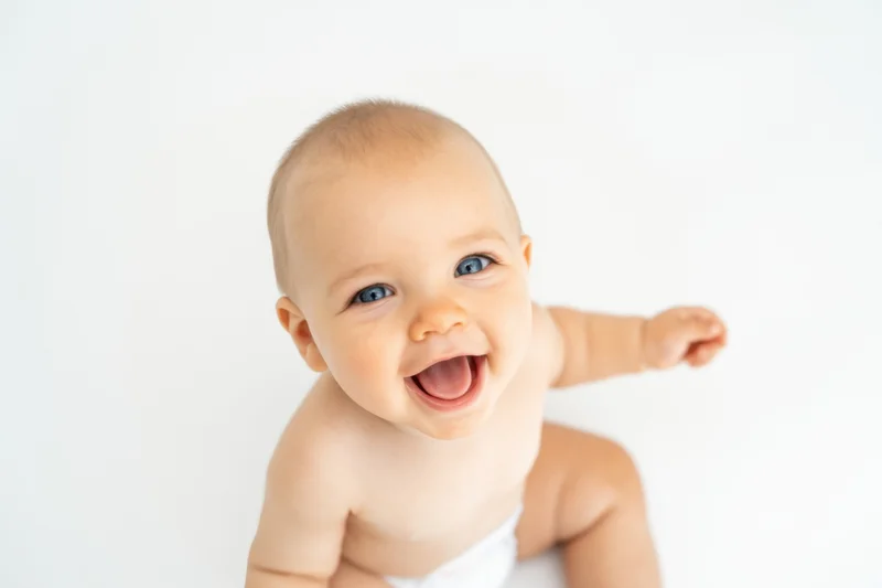 Baby smiling with blue eyes on white studio background