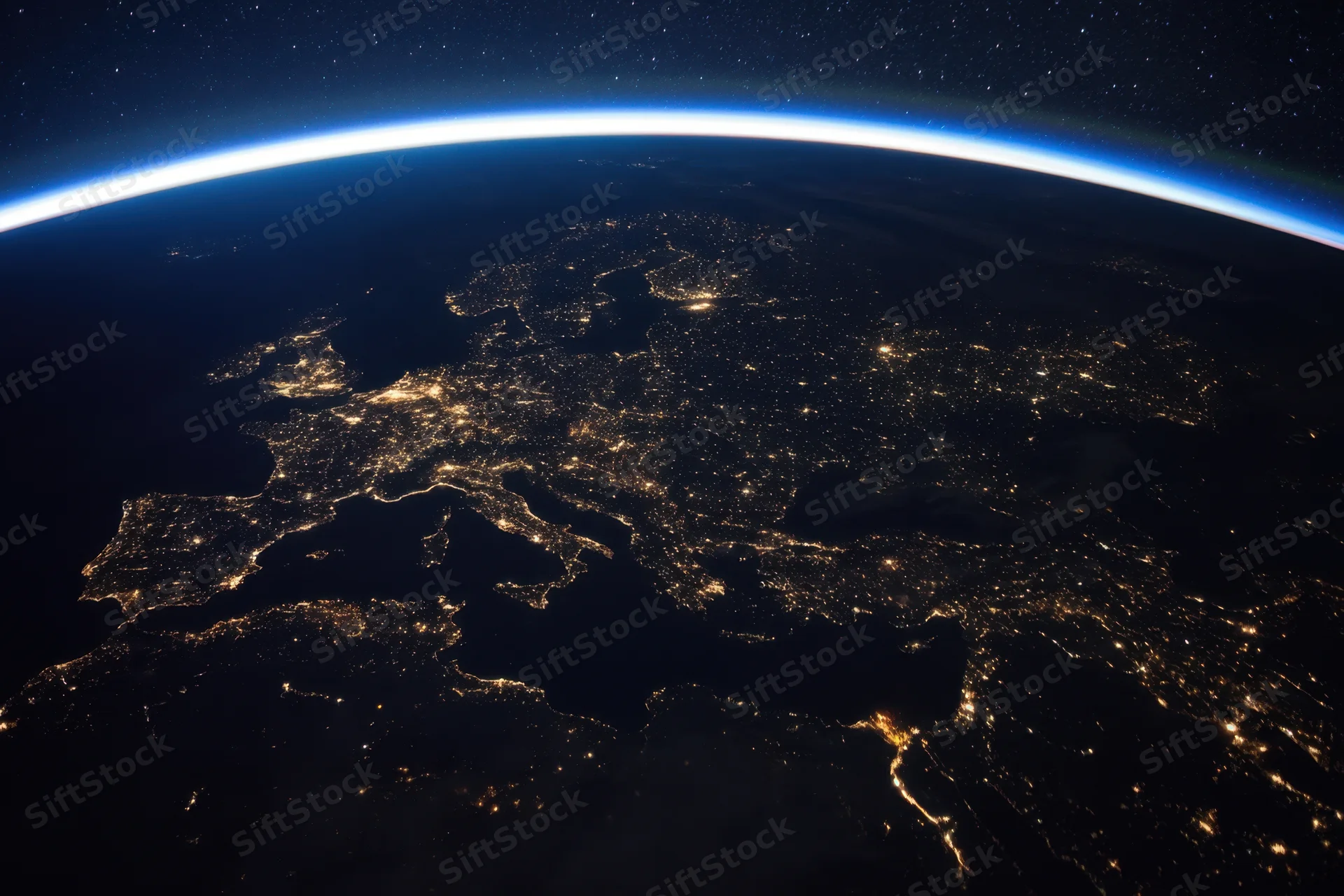 Earth viewed from orbit at night showing illuminated cities across europe