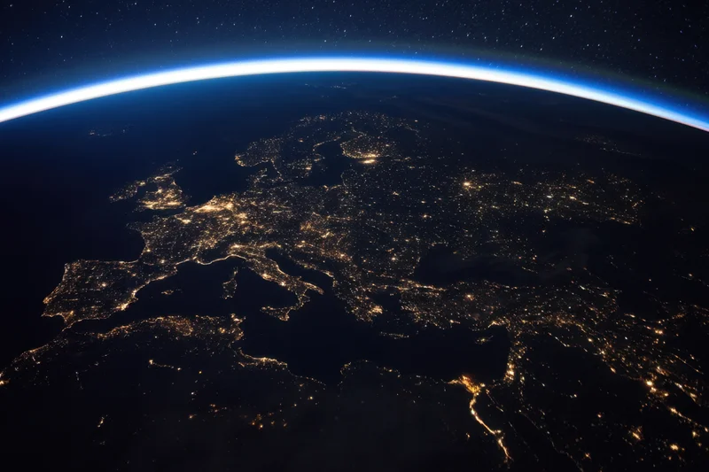 Earth viewed from orbit at night showing illuminated cities across europe