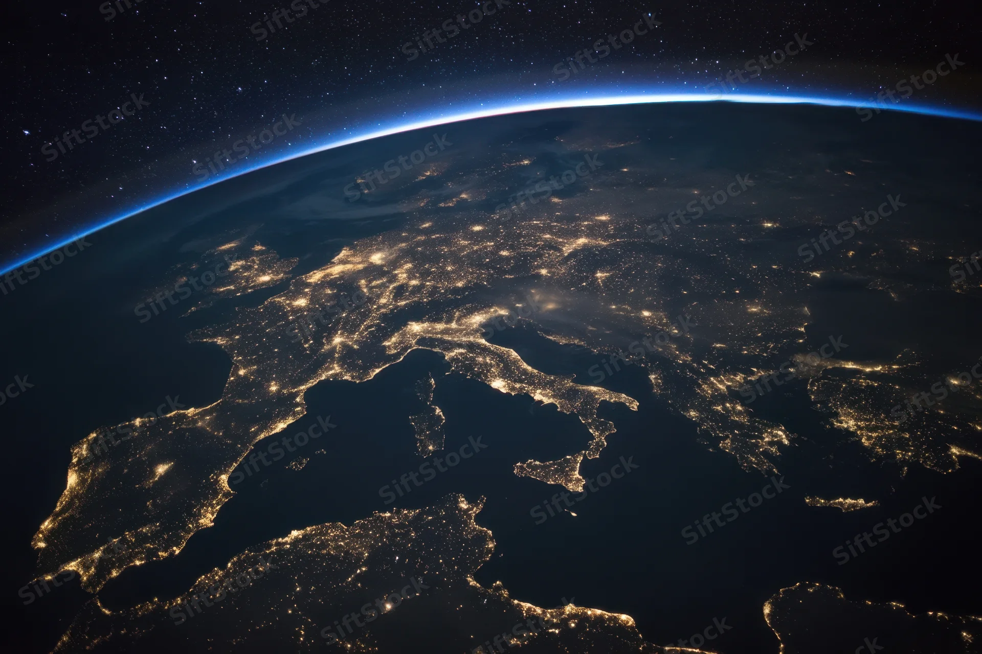 View of earth from orbit at night showing illuminated cities across europe and the mediterranean