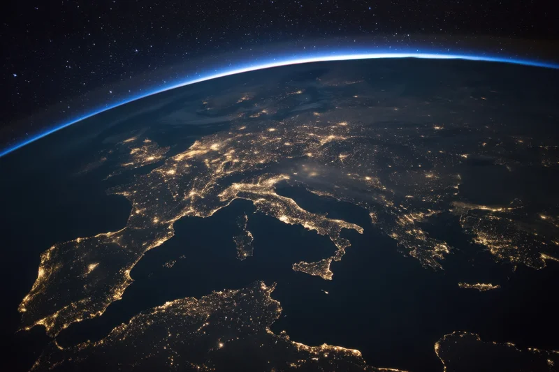 View of earth from orbit at night showing illuminated cities across europe and the mediterranean