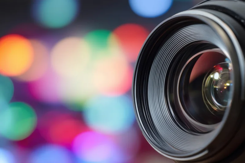 Close-up of a camera lens with colorful bokeh lights in the background
