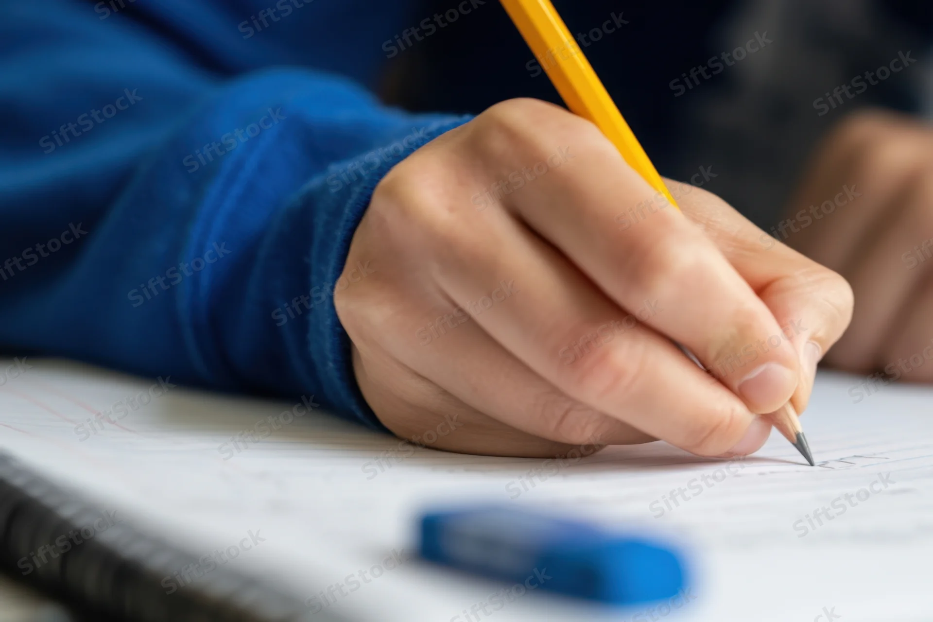 Hand writing with yellow pencil on lined notebook paper