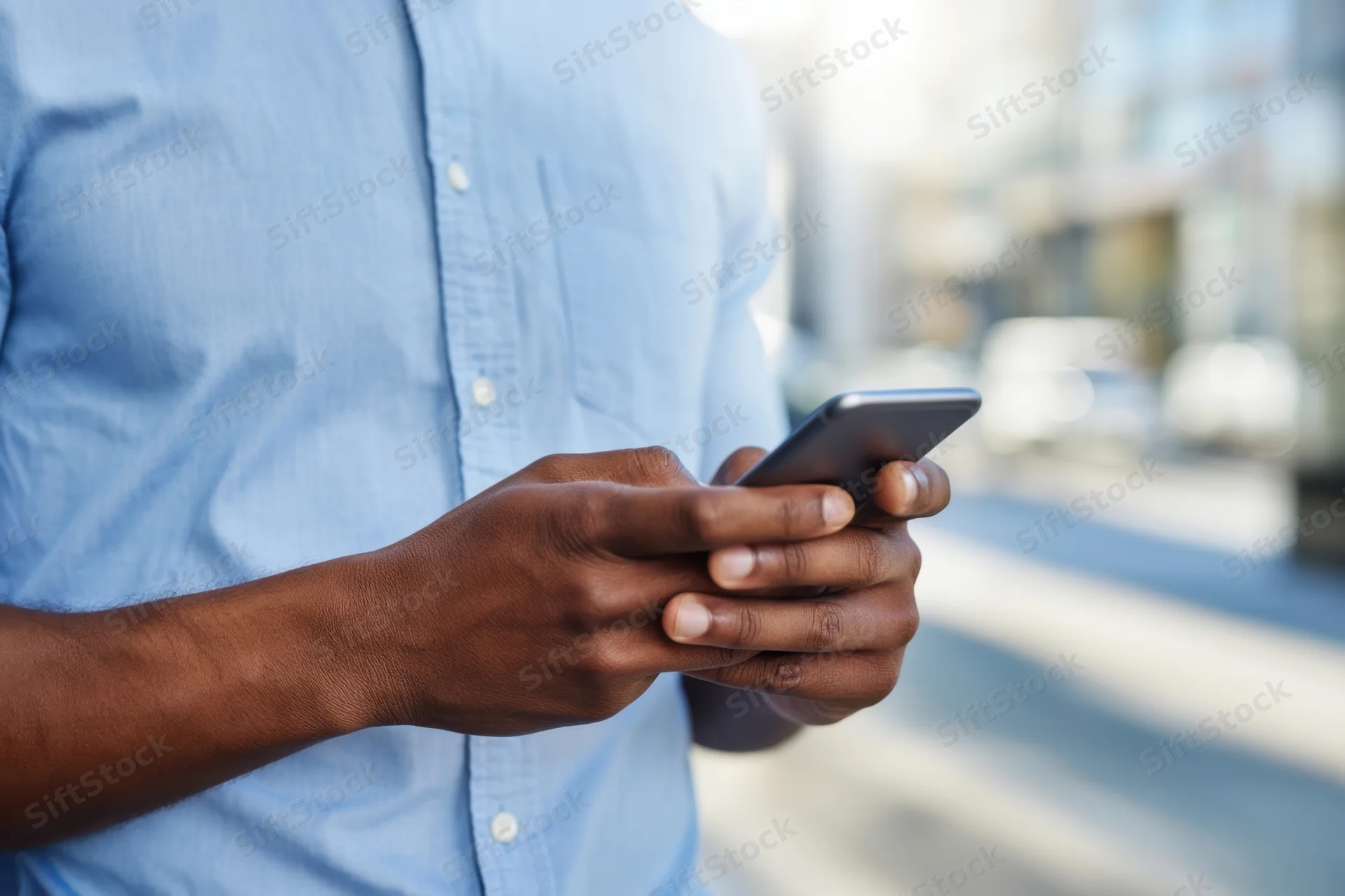 Man using smartphone outdoors in city street setting