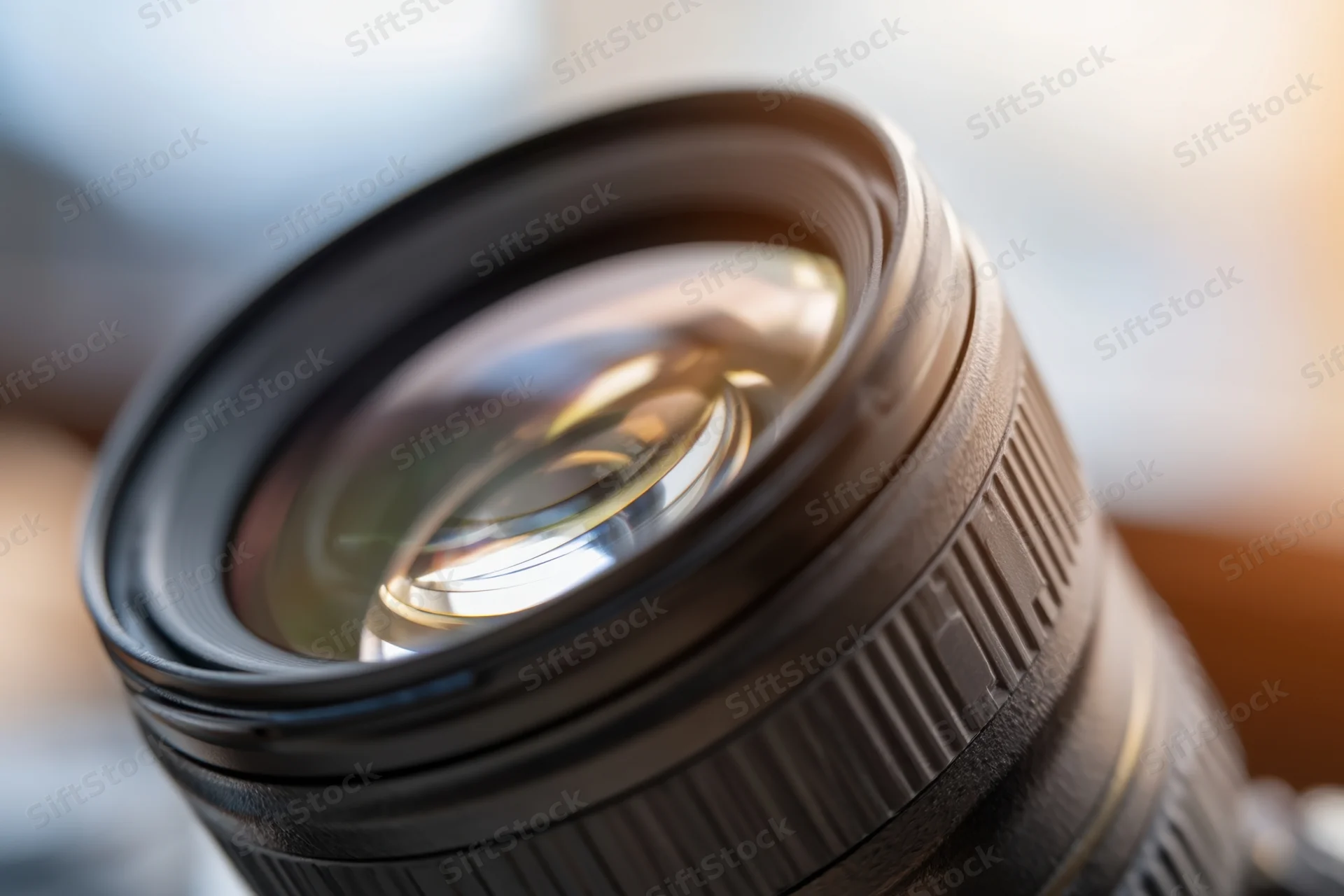 Close-up of a professional camera lens showing glass elements and reflections