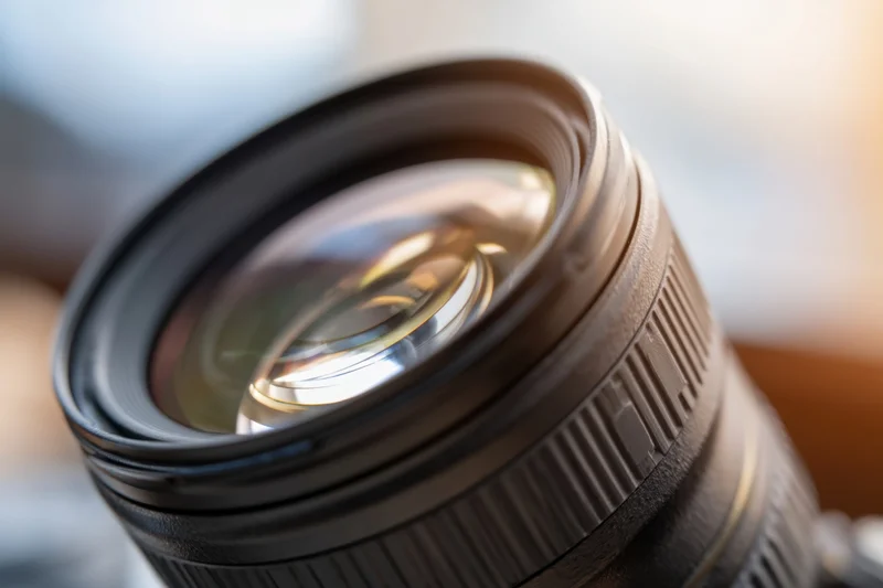 Close-up of a professional camera lens showing glass elements and reflections