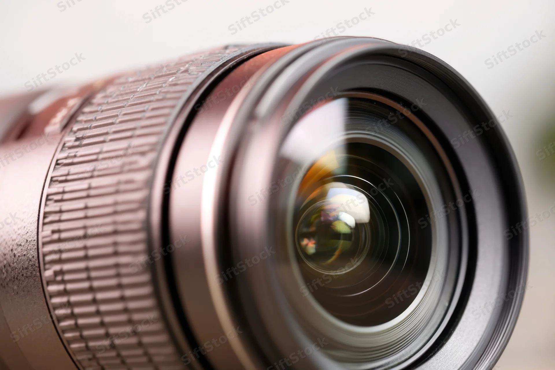 Close-up of a professional camera lens showing glass elements and reflections