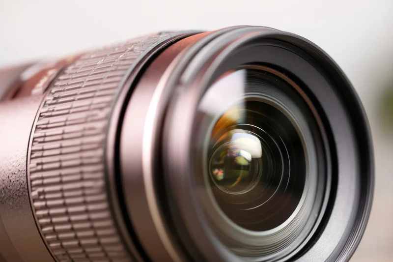 Close-up of a professional camera lens showing glass elements and reflections
