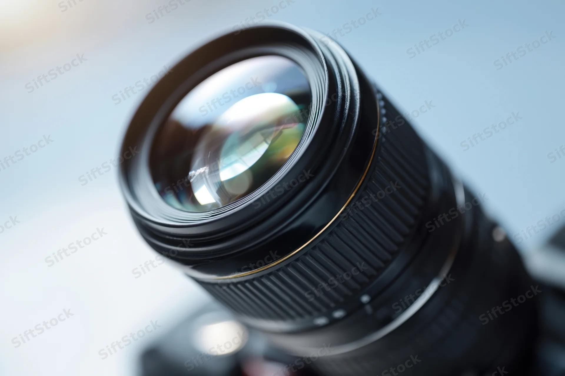 Close-up of a professional camera lens showing glass elements and reflections