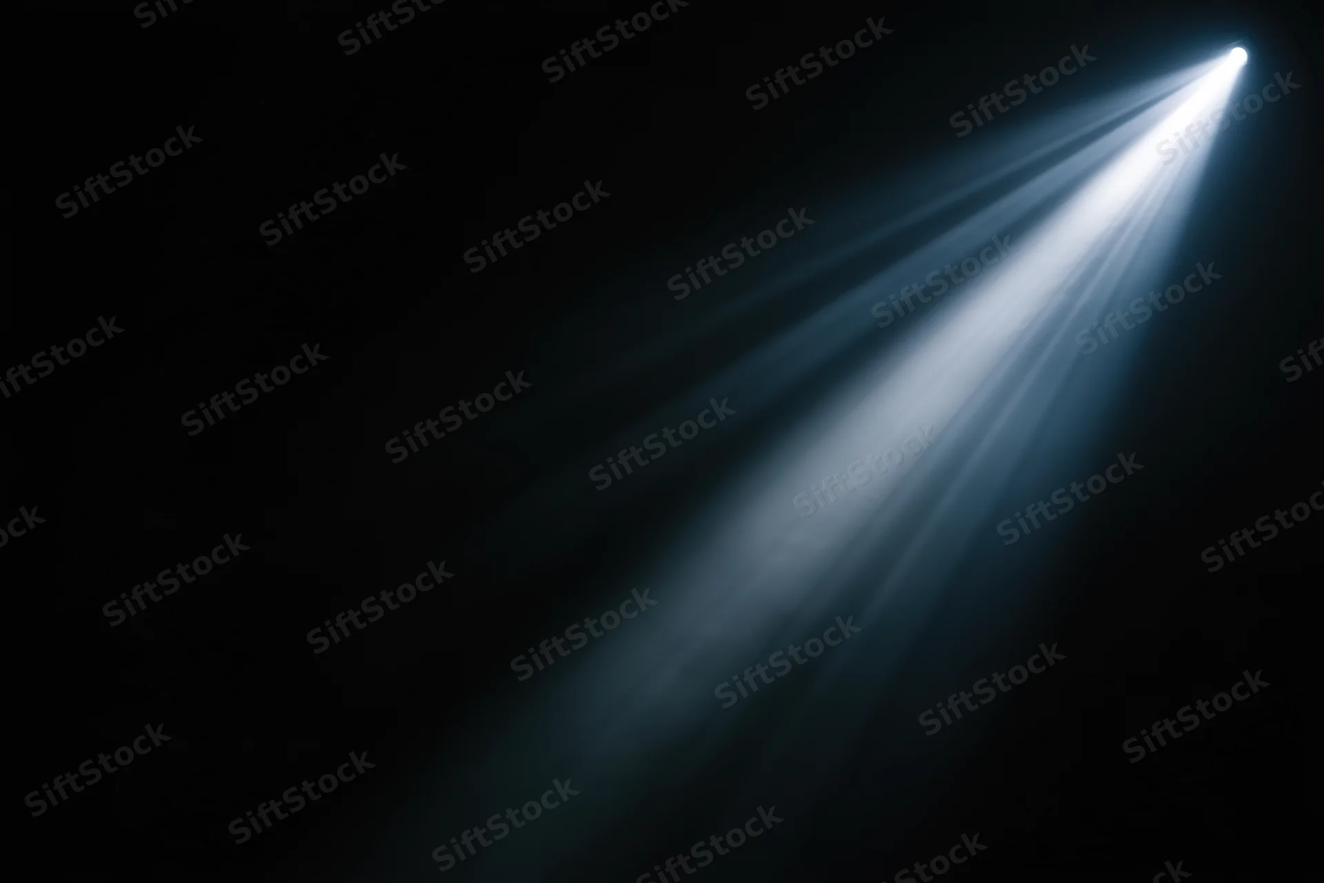 Diagonal beam of light cutting through dark void
