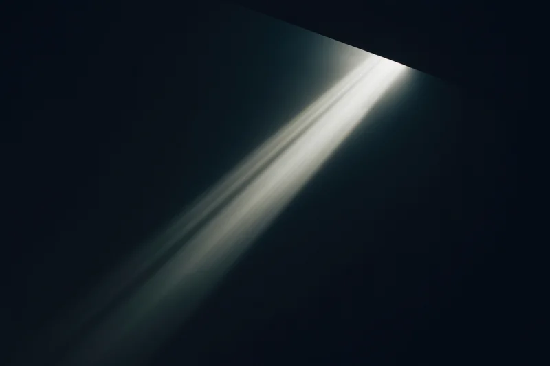 Diagonal beam of light cutting through dark void