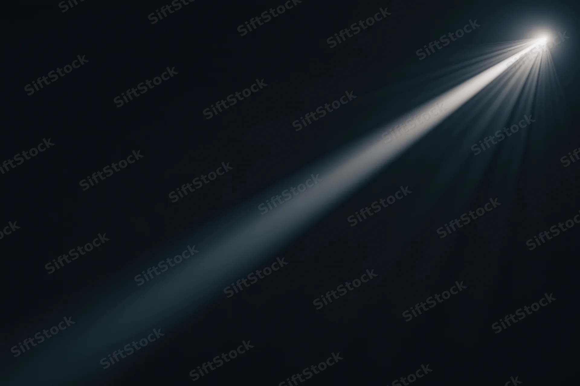 Diagonal beam of light cutting through dark void